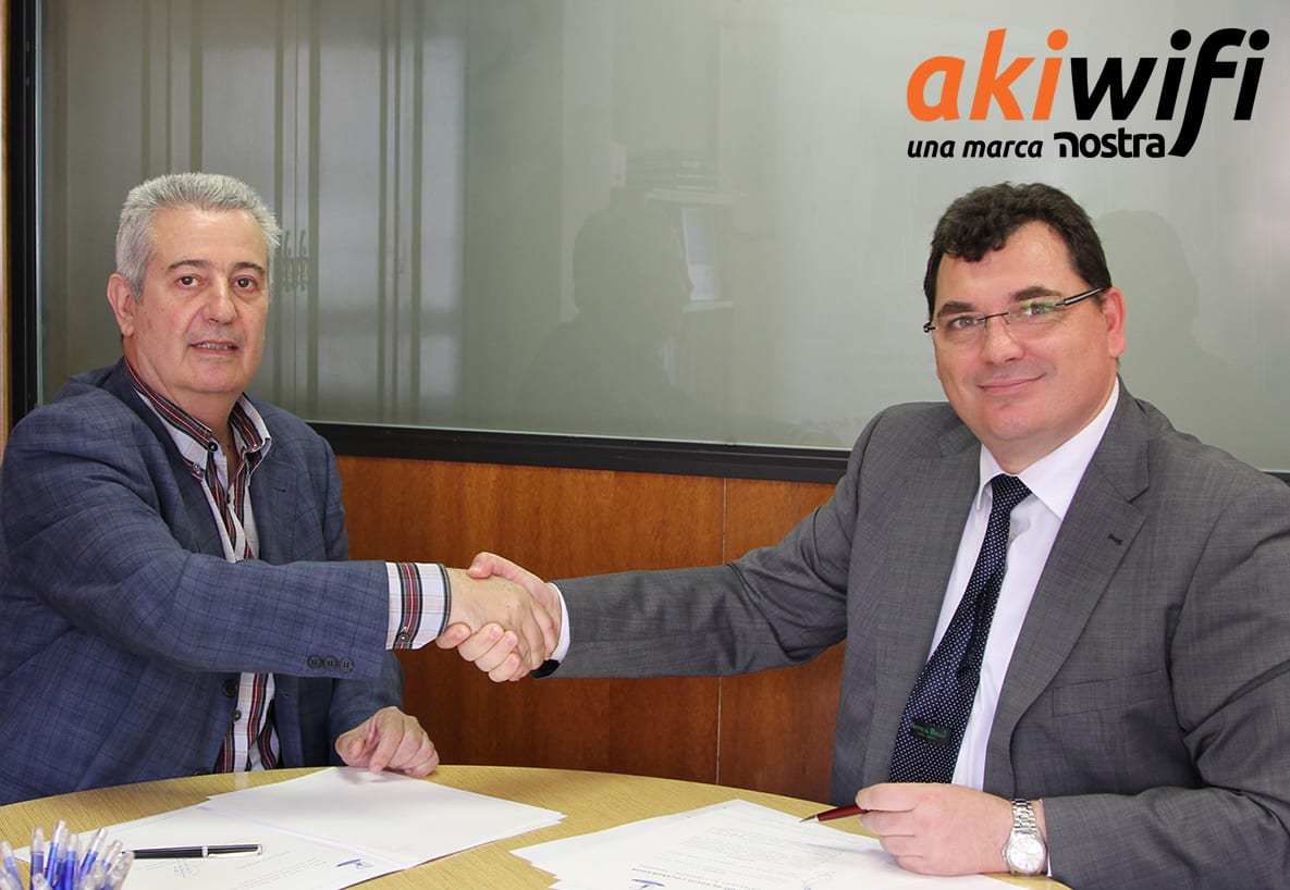 Dos hombres dándose la mano en una oficina, con el logo de akiwifi al fondo