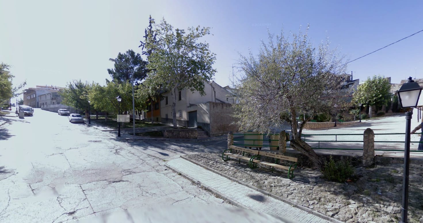 Calle arbolada de Valdeganga, con casas tradicionales y bancos