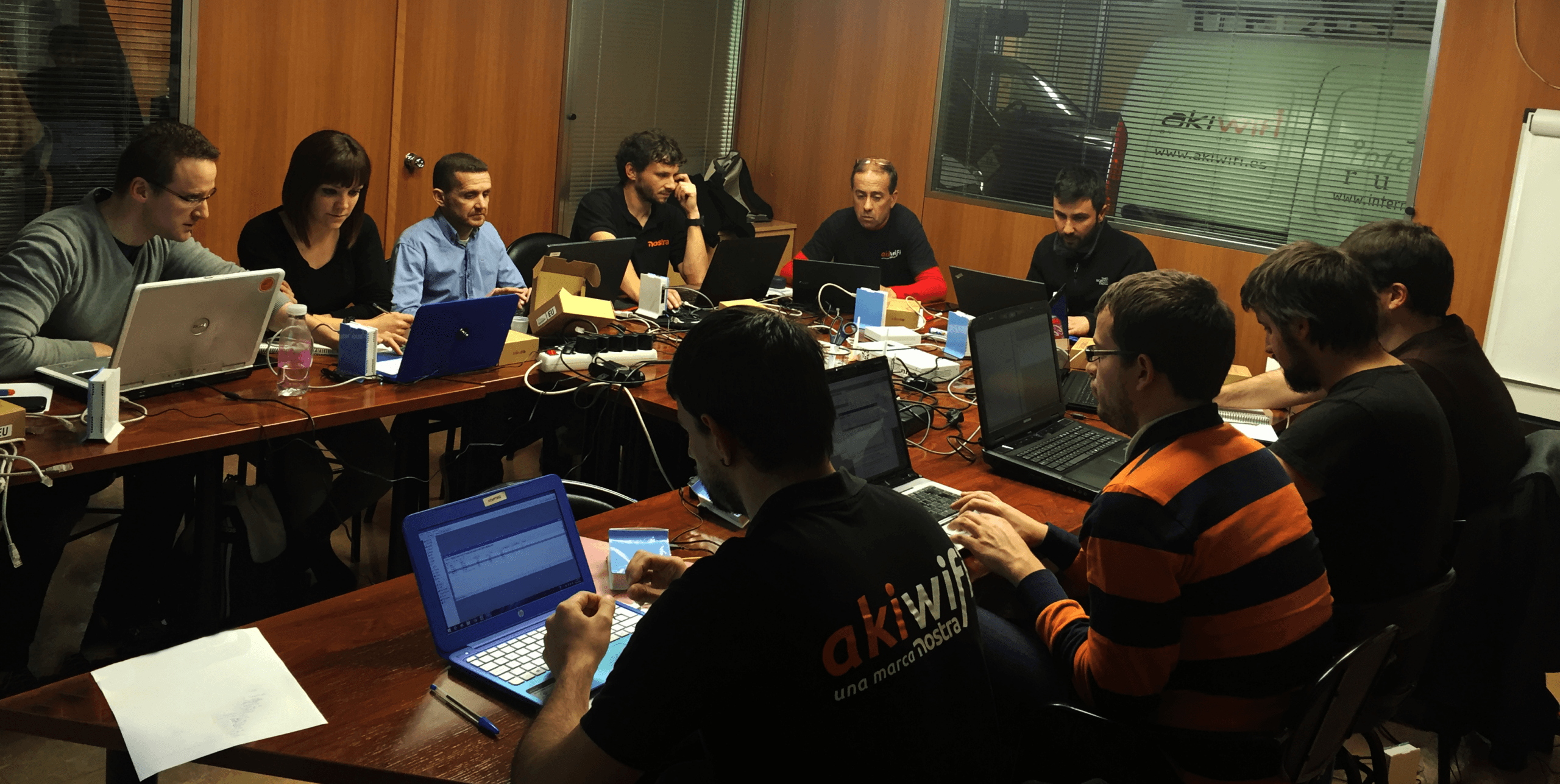 Grupo de técnicos de akiwifi trabajando con sus portátiles durante una formación MikroTik en la sede central