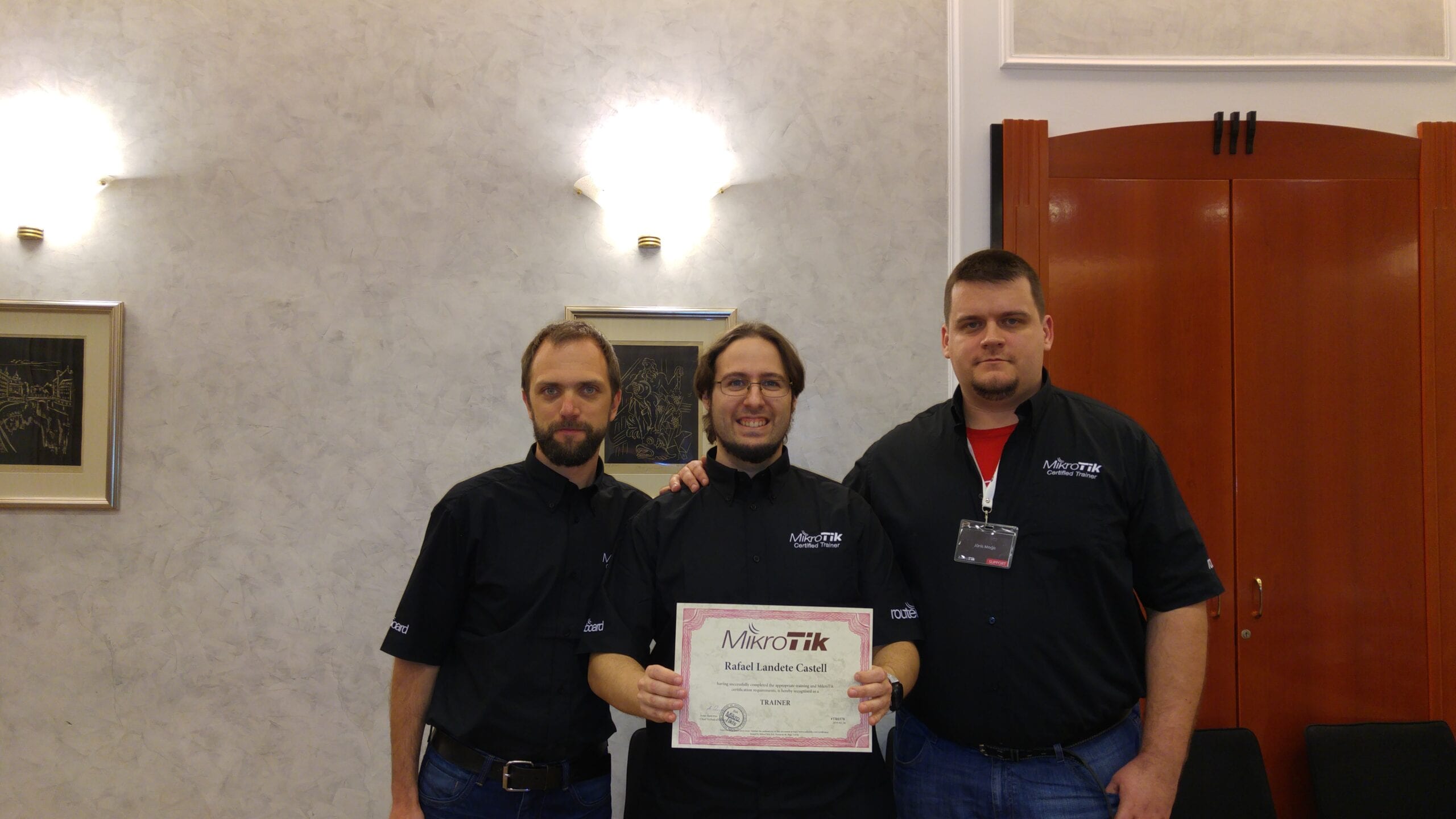 Tres técnicos de akiwifi posando con el certificado de formador oficial MikroTik