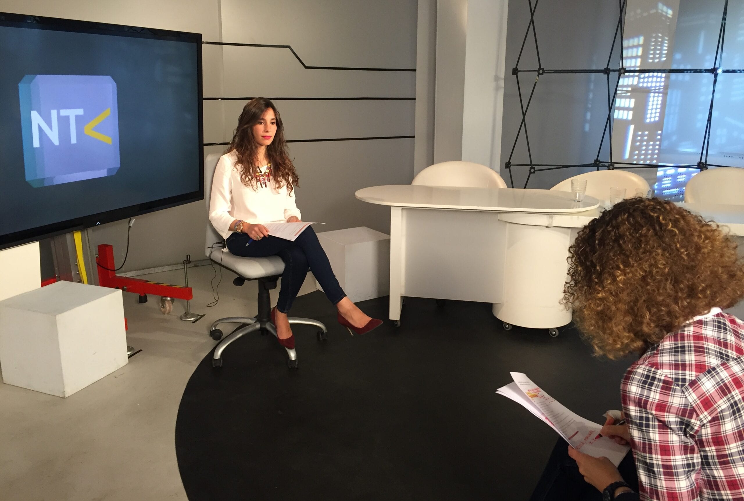Entrevista en el plató de un canal de televisión, con el logo NTK proyectado en pantalla