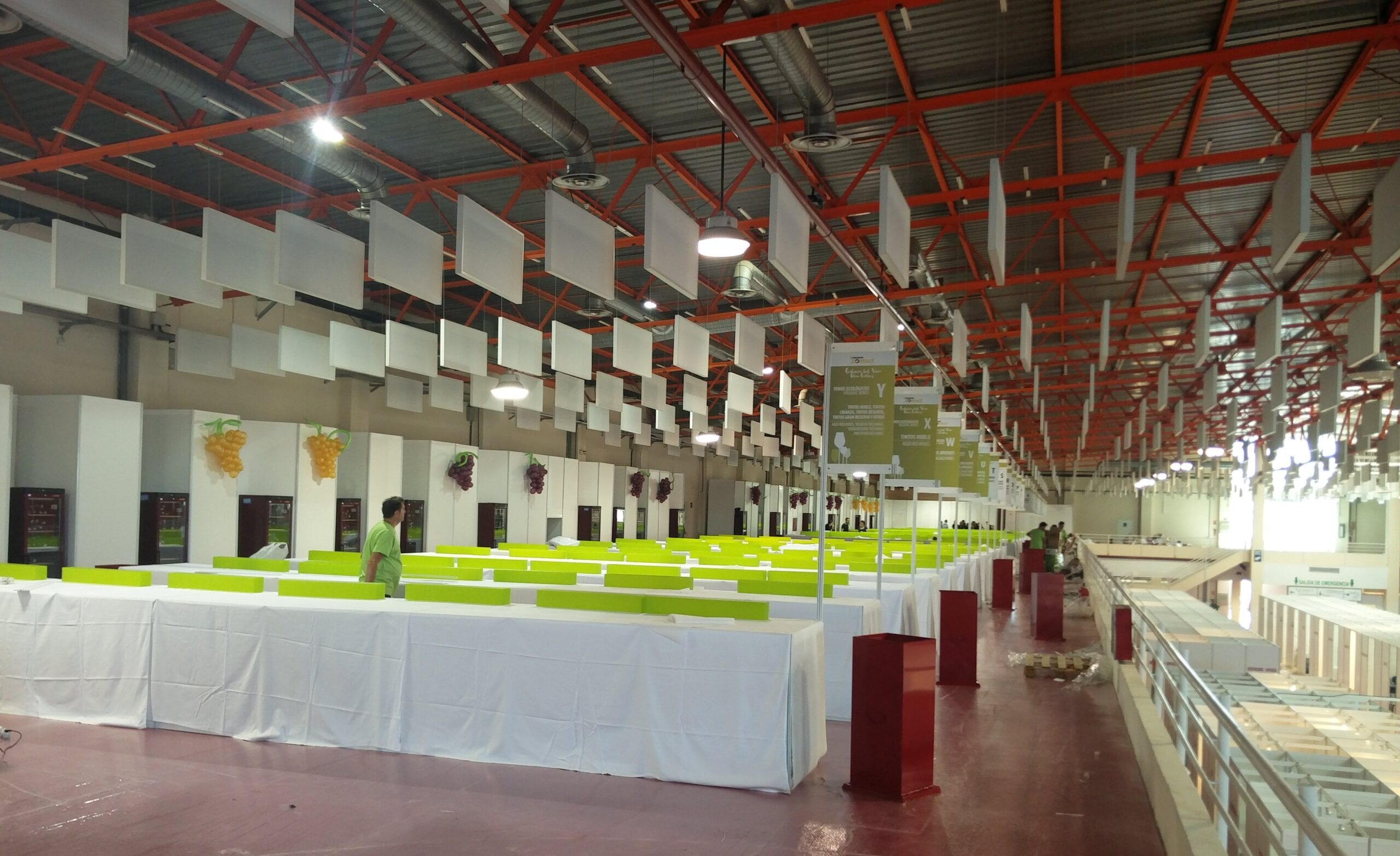Interior del pabellón ferial de Ciudad Real preparado para una feria, con expositores y mesas antes de la apertura
