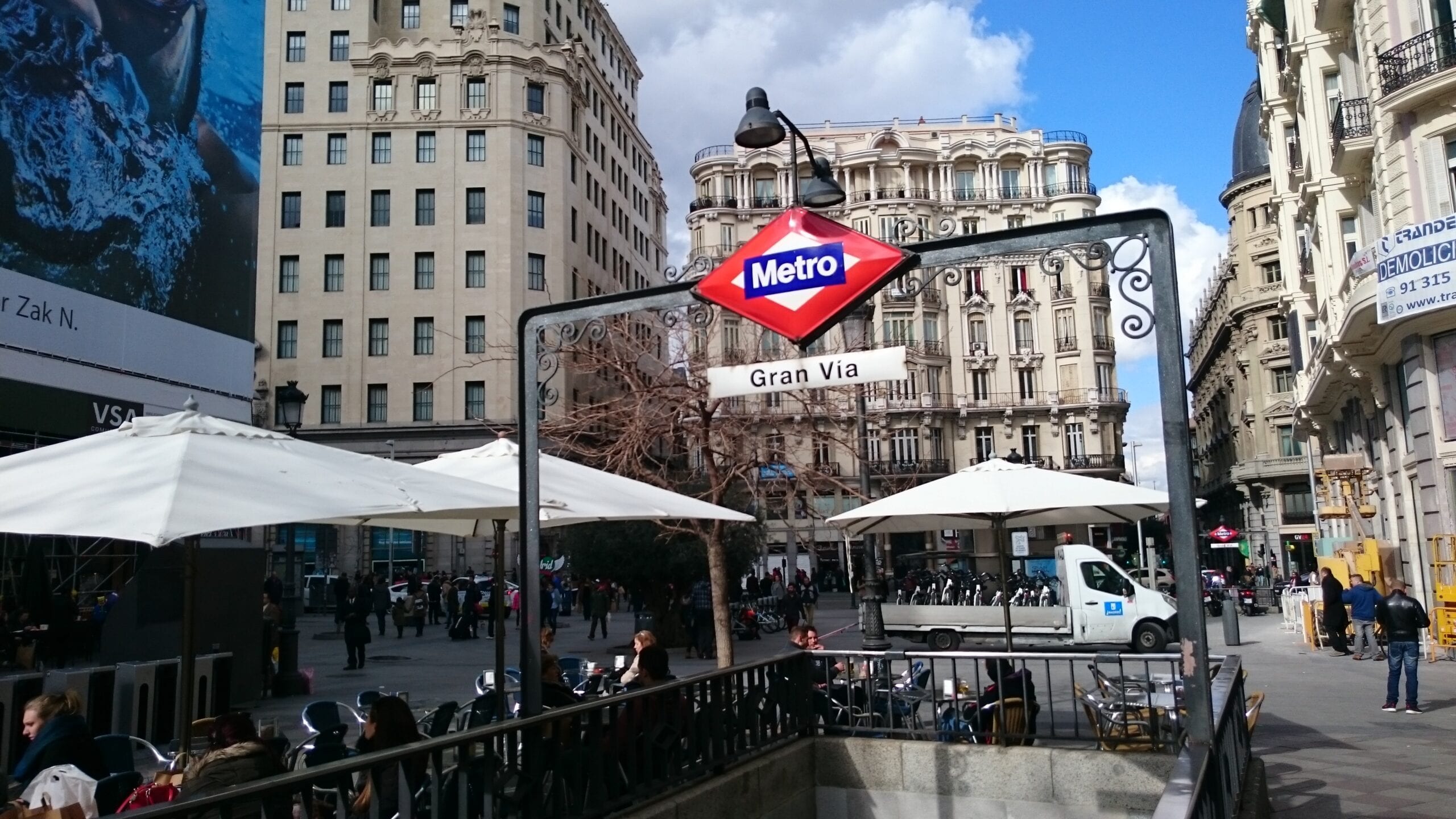 Boca de metro de Gran Vía en Madrid, con terrazas y edificios históricos alrededor