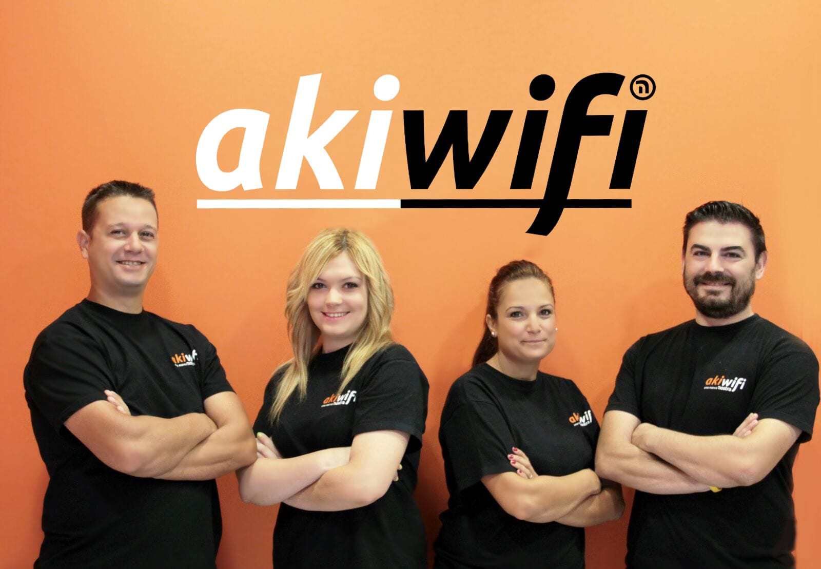 Dos técnicos de una tienda akiwifi sujetan un cartel promocional de internet por 14,95 euros, junto a un árbol de Navidad