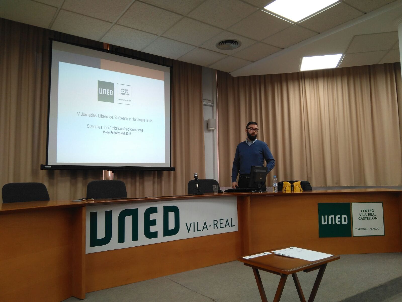 Ponente de akiwifi impartiendo una charla sobre sistemas inalámbricos y radioenlaces en el salón de actos de la UNED Vila-real