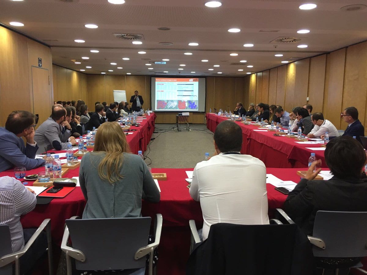 Sala de conferencias con mesas en forma de U y ponente ante una pantalla con datos de akiwifi