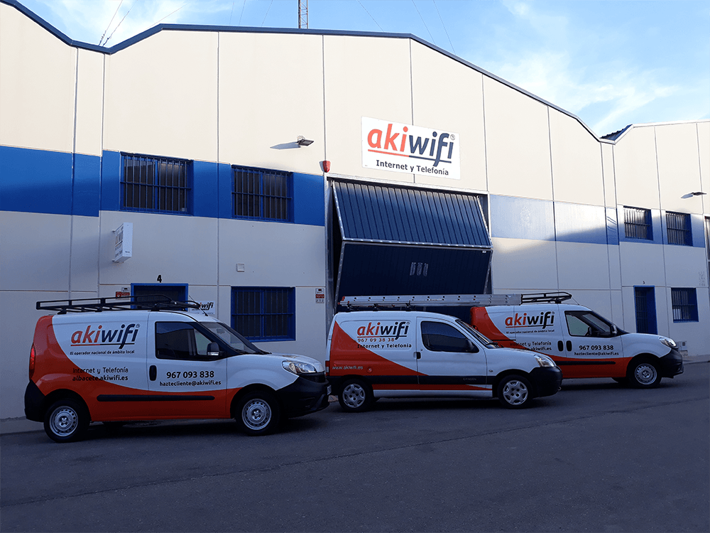 Tres furgonetas de akiwifi Albacete aparcadas frente a la nave de la empresa