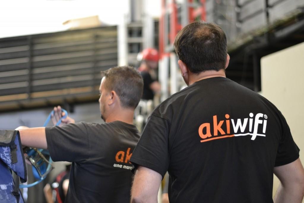 Dos técnicos de akiwifi de espaldas, con el logo de la marca en la camiseta, durante una instalación