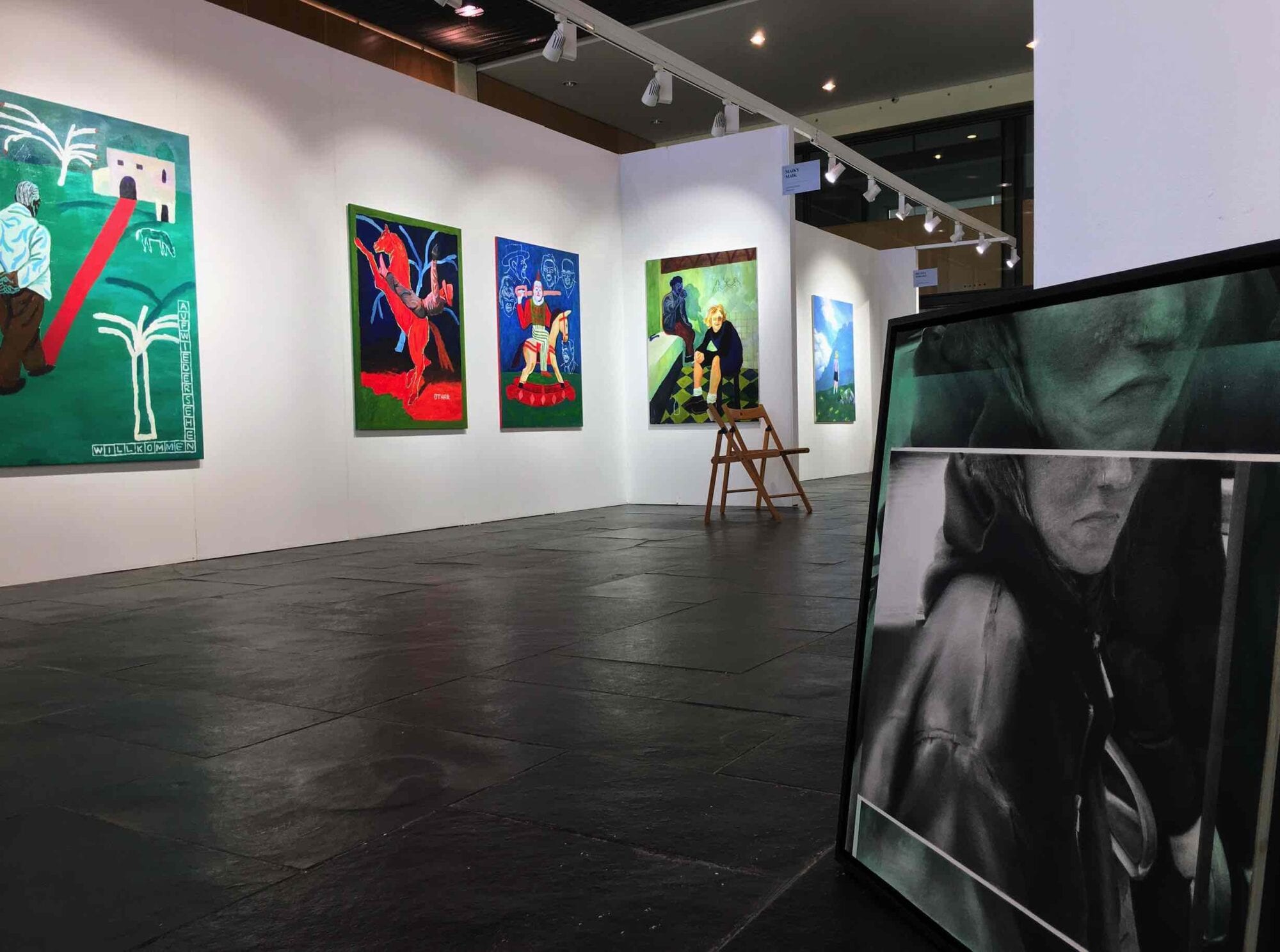 Sala de exposición de la Feria MARTE de Castellón con obras de arte contemporáneo en paneles blancos