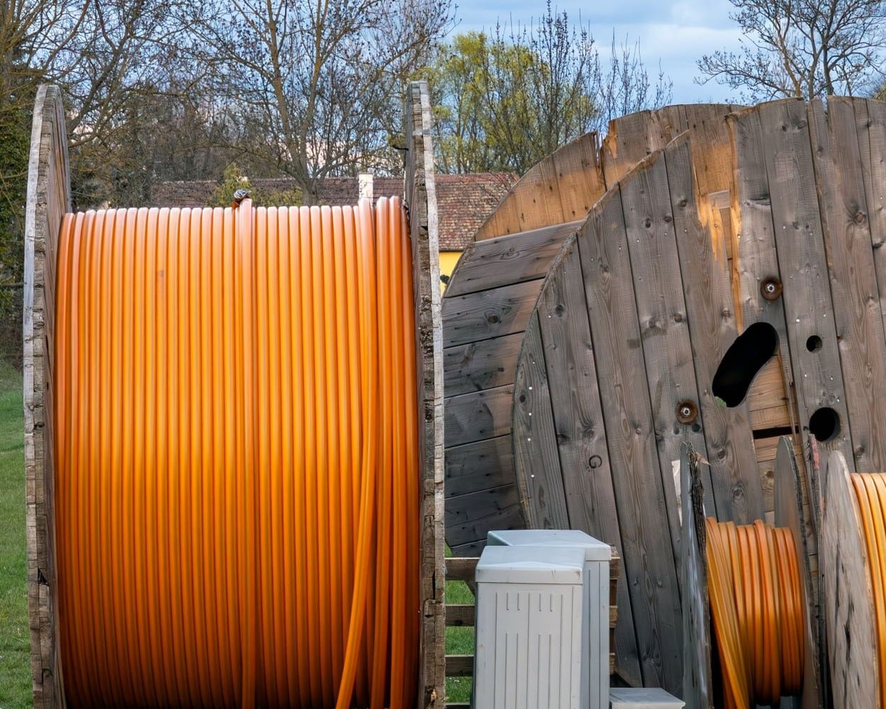 Bobinas de cable para fibra óptica guardadas al aire libre en una zona rural, sin instalar